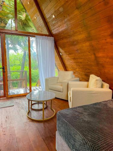 a room with a bed and a couch and a table at Leopard Inn Wilpattu in Ilavankulam