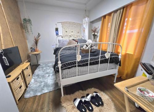 a bedroom with a bed and two pairs of shoes at Cozy Boho Room at the Heart of Vancouver! Private Parking, Self Check-in & just 4 mins to Metrotown! in Burnaby