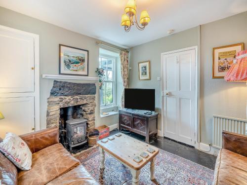 a living room with a couch and a fireplace at Howe Cottage in Bowness-on-Windermere