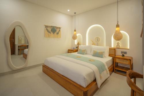 a bedroom with a large bed and a mirror at Monstera Uluwatu in Uluwatu