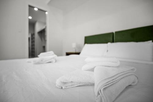 a white bed with towels on it with a mirror at Harborview Modern Apartment 8F in Victor Harbor