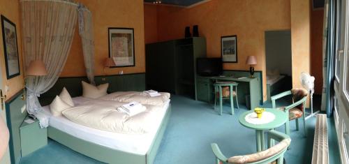 a bedroom with a bed and a small table and a tableablish at Hotel Reifenstein in Kleinbartloff