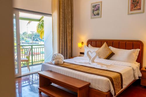 a bedroom with a bed and a balcony at River Deck Baga Beach Front in Calangute