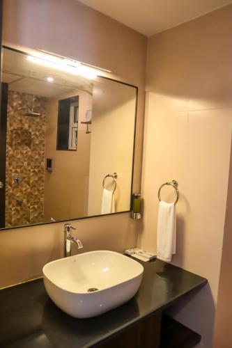 a bathroom with a sink and a large mirror at River Deck Baga Beach Front in Calangute