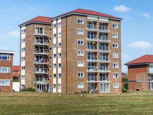a large brick building with a grass field in front at Galley Hill Aspect in Bexhill