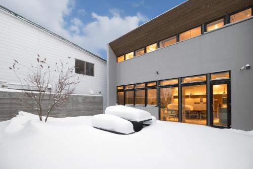 a large house with a snow covered yard at amairo Villa in Asahikawa