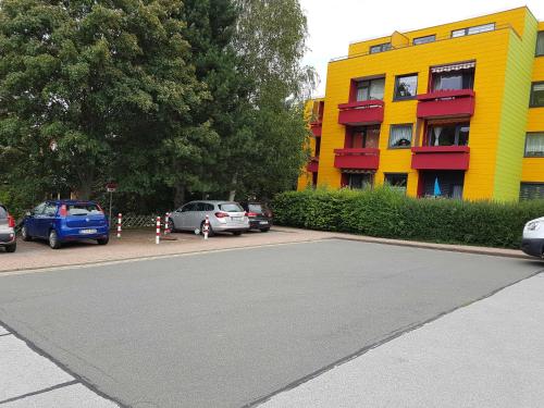 a yellow building with cars parked in a parking lot at Ferienwohnung Schnuffi Wolfgang Kresse in Bad Harzburg