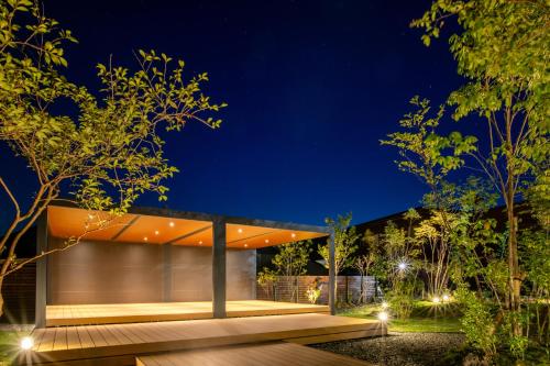 a house with a wooden deck at night at Aso Hotel in Aso