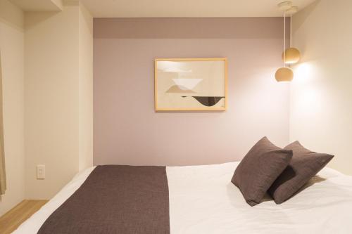a bedroom with a bed and a painting on the wall at PREMIER suite Shinjuku West 2F in Tokyo