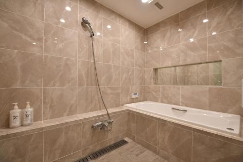 a bathroom with a shower and a bath tub at Buckeye House by the lake in Yamanakako