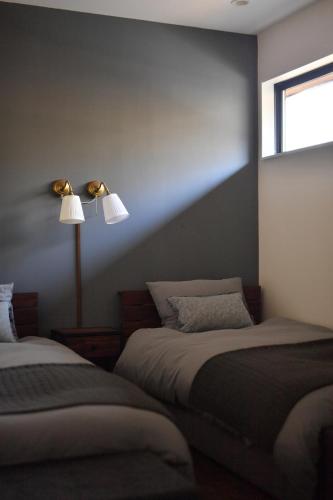 a bedroom with two beds and a lamp at Buckeye House by the lake in Yamanakako