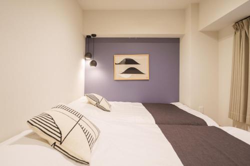 a bed with two pillows on it in a bedroom at PREMIER suite Shinjuku West 2F in Tokyo