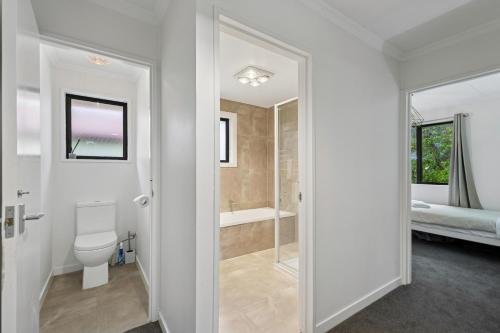 a bathroom with a toilet and a bath tub at Rees on Reid - Arrowtown Holiday Home in Arrowtown
