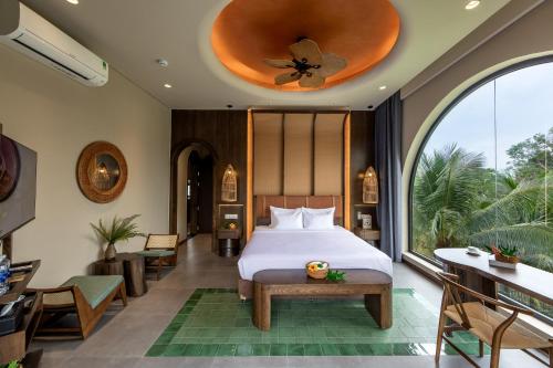 a bedroom with a bed and a large window at Emerald Garden Retreat in Phú Quốc