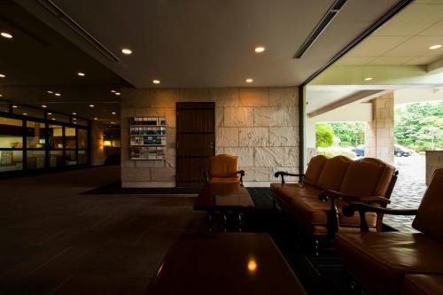 a lobby with couches and chairs in a building at Hakone Sengokuhara Prince Hotel in Hakone