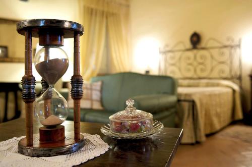 a living room with a table with an antique clock and a table sidx sidx sidx at Palazzo Leti Residenza d'Epoca in Spoleto