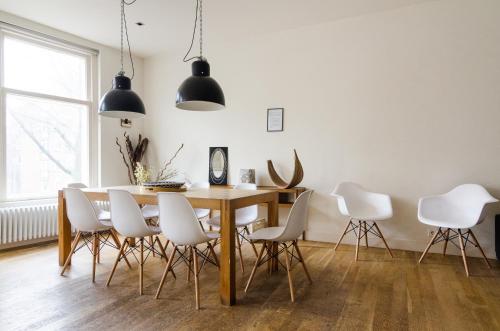 ein Esszimmer mit einem Tisch und weißen Stühlen in der Unterkunft Marnix Design: Downtown Dream in Amsterdam