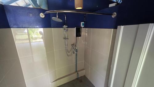 a shower in a bathroom with a blue ceiling at OneSeasonFarm Chiangsaen in Chiang Saen