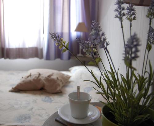 a table with a coffee cup and flowers on a bed at PortAtenea - Atenea Collection in Agrigento