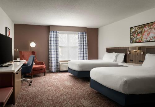 a hotel room with two beds and a television at Hilton Garden Inn Jackson-Madison in Madison