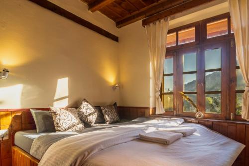 a bed in a room with a large window at Timberwolves Vintage Manali in Manāli