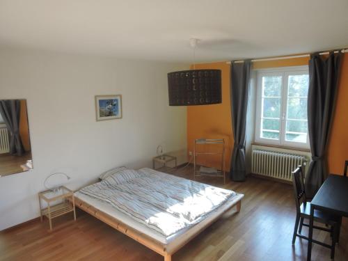 Schlafzimmer mit einem Bett, einem Tisch und einem Fenster in der Unterkunft VINITA Chambres d'hôtes in Boncourt
