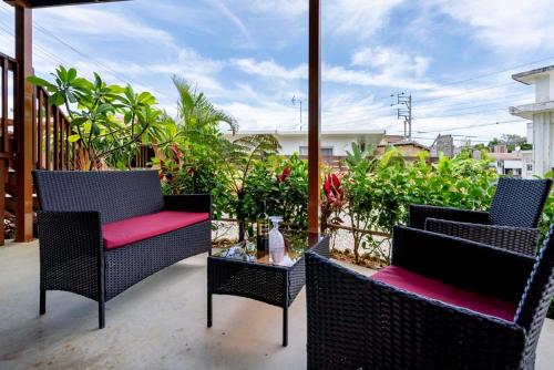 a patio with two chairs and a glass table at Island Breeze - Round House with BBQ - Wooden Hot Tub - Beach in Onna