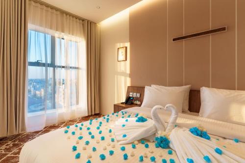 a bed with two swans made out of blue flowers at Jarzez Inn Hotel Azaiba فندق جرزيز إن العذيبة in Muscat