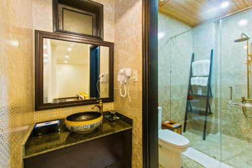uma casa de banho com um lavatório, um WC e um espelho. em Hoi An Hai Au Boutique Hotel em Hoi An