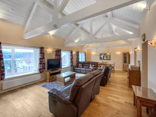 a living room with couches and a tv at Pilots Loft in Menai Bridge