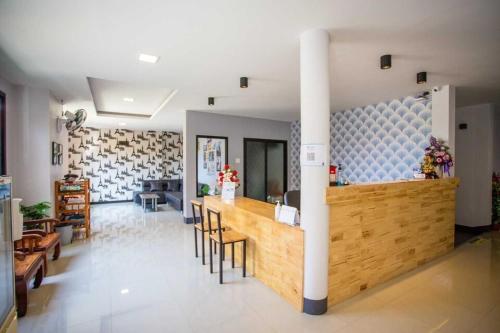 a lobby with a counter and a bar with chairs at Nakarin Hotel in Amnat Charoen