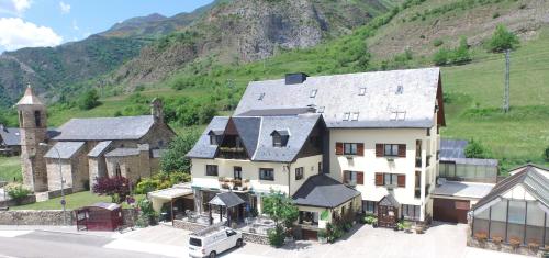 an aerial view of a large house with a mountain at Hotel Edelweiss in Arties