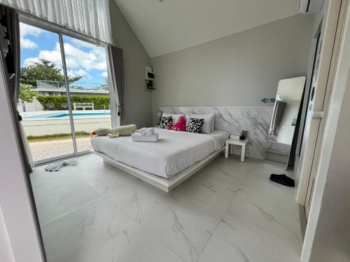 a bedroom with a bed and a large window at Miami Seaview in Ban Pak Ba Ra