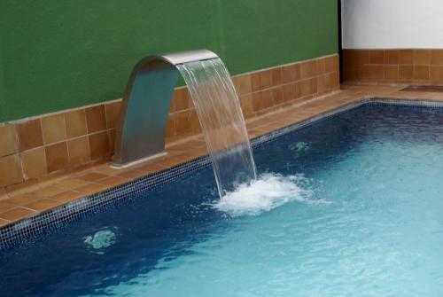 a water fountain in a swimming pool at Hotel Edelweiss in Arties