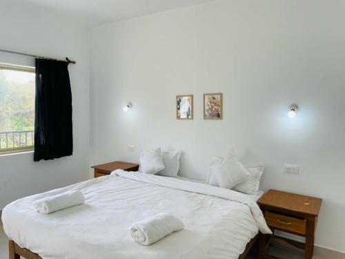 a bedroom with a large bed with white sheets and pillows at Grace villa in Mandrem