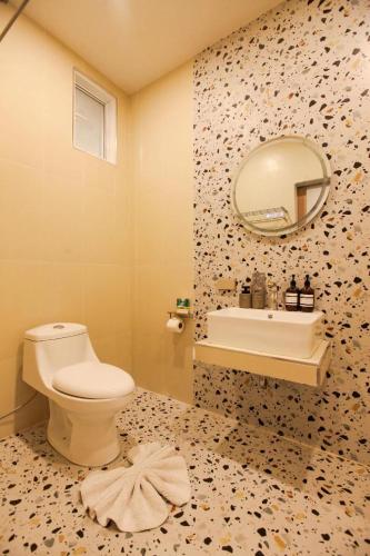 a bathroom with a toilet and a sink and a mirror at Miami Seaview in Ban Pak Ba Ra