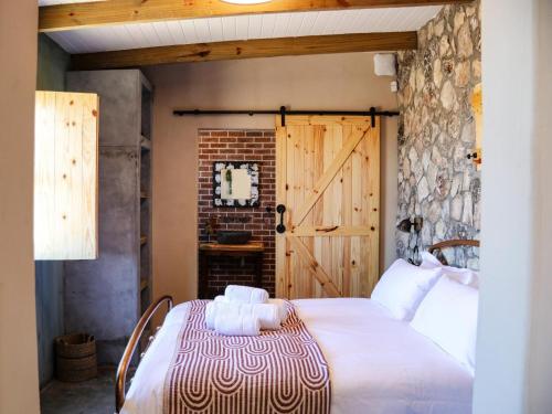 a bedroom with a large bed with a wooden door at Die Stalle by Chickania in Jacobs Bay