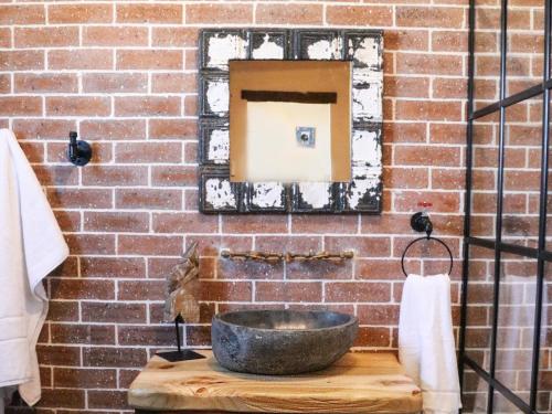 a bathroom with a stone sink on a brick wall at Die Stalle by Chickania in Jacobs Bay