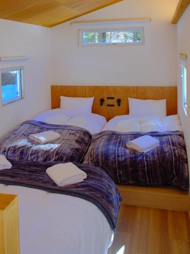 a bedroom with two beds with white pillows at 雪箱神楽 Yukibako Kagura 一棟貸切かぐらスキー場徒歩7分 in Yuzawa