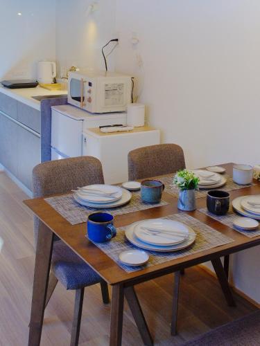 a wooden table with plates on it in a kitchen at 雪箱神楽 Yukibako Kagura 一棟貸切かぐらスキー場徒歩7分 in Yuzawa