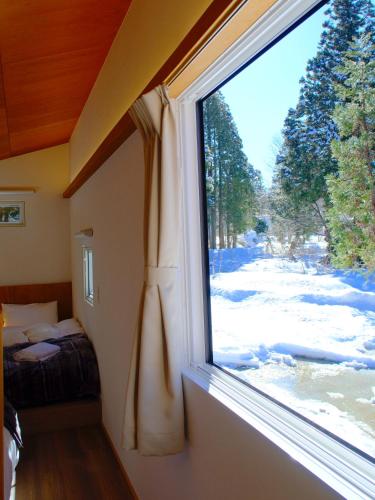 a window in a room with a view of a bedroom at 雪箱神楽 Yukibako Kagura 一棟貸切かぐらスキー場徒歩7分 in Yuzawa