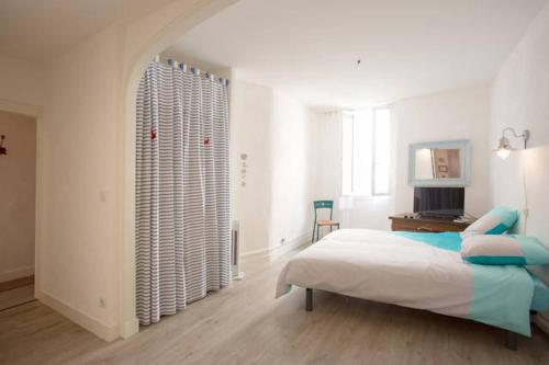a white bedroom with a bed and a window at Belle Vue YourHostHelper in La Ciotat