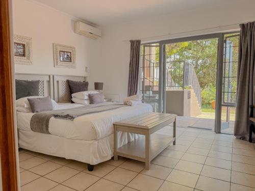 a bedroom with two beds and a table in it at Amoris Guesthouse - Waterkloof ridge in Pretoria