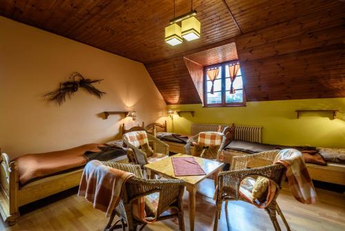 a living room with a table and chairs and a bed at Rezort u Bobiho in Nový Tekov