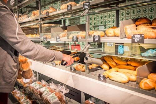 a person is purchasing bread in a grocery store at Vakantiepark Dennenoord in Den Burg