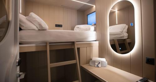 a small room with two bunk beds and a mirror at Wostel The Comfort Hostel in Málaga