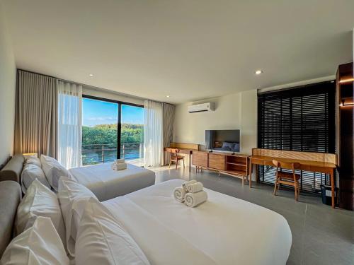 a hotel room with two beds and a television at Rivendale in Ban Gaeng Cho