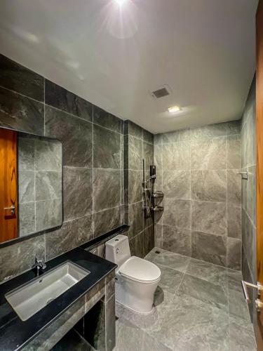a bathroom with a toilet and a sink and a mirror at Rivendale in Ban Gaeng Cho