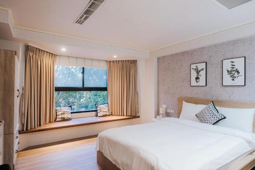 a bedroom with a large bed and a window at Meworld Hotel - Zhongshan in Taipei