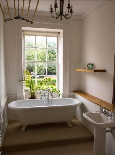 a bathroom with a large tub and a window at East Pallant Bed and Breakfast, Located in Large Georgian Townhouse in Central Chichester in Chichester